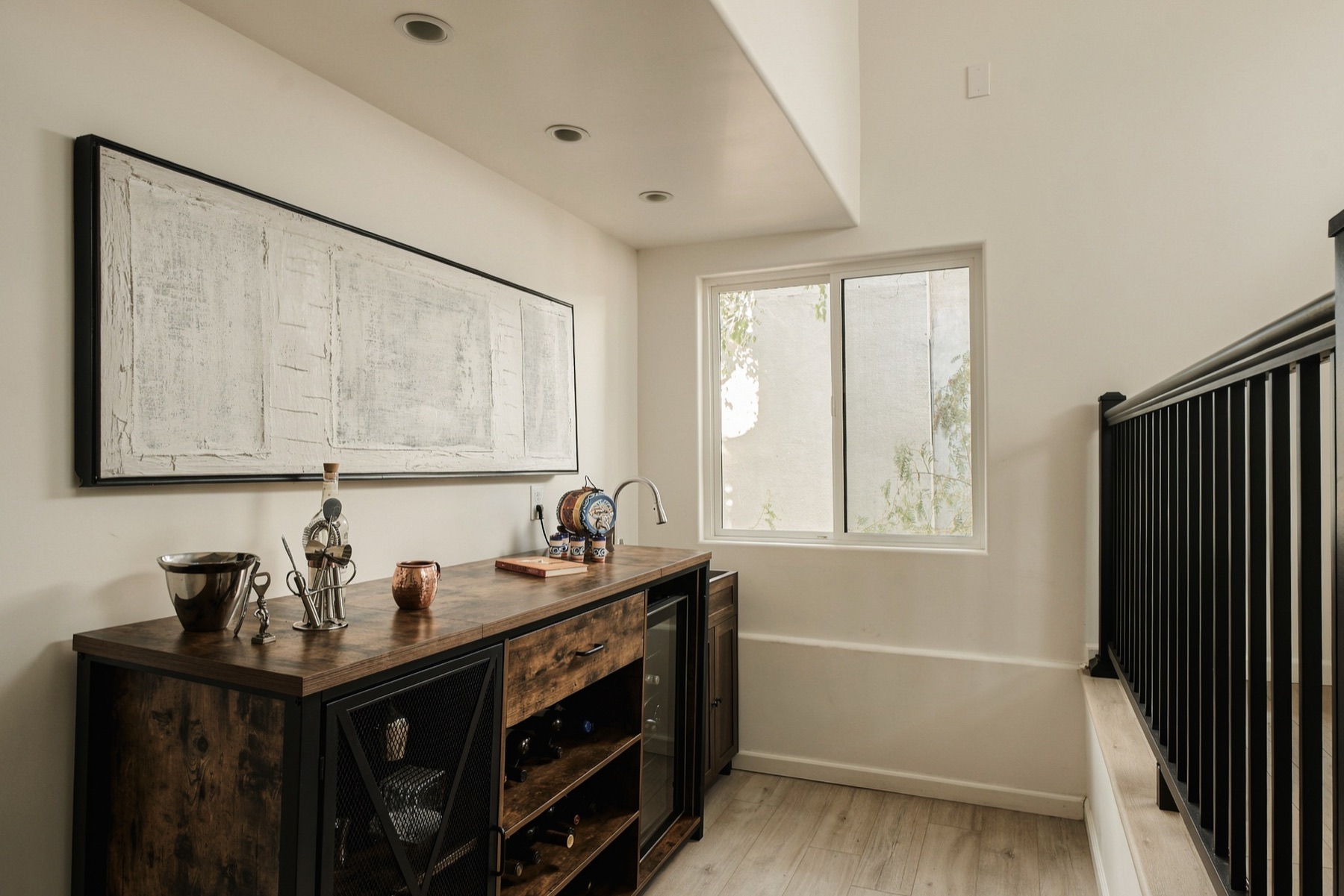 Wine bar nook with a beverage fridge beside the stair