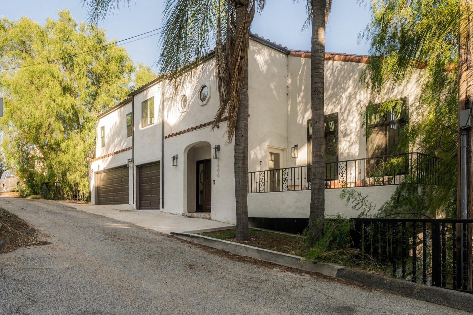 The front of the home from the street, framed by trees